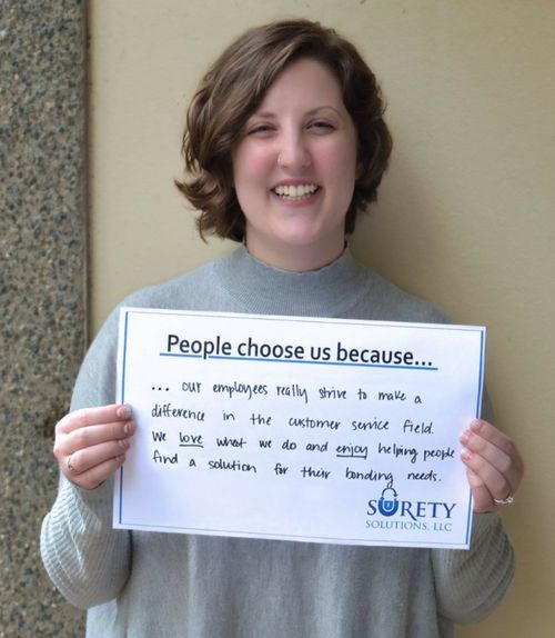 Laura Marsland holding a people choose surety solutions because sign