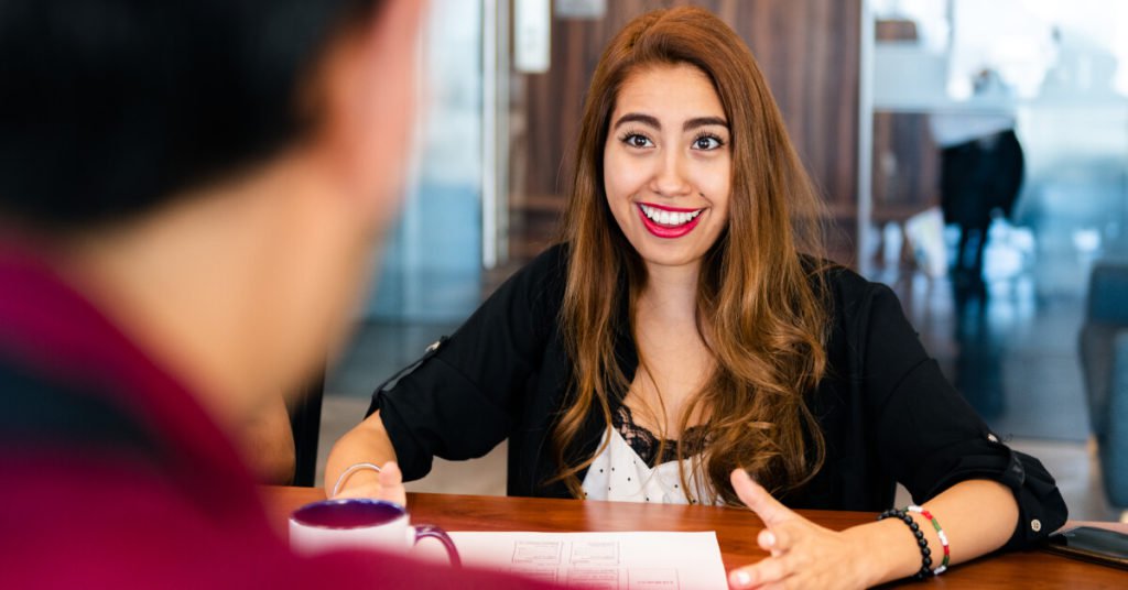 woman smiling while speaking with man