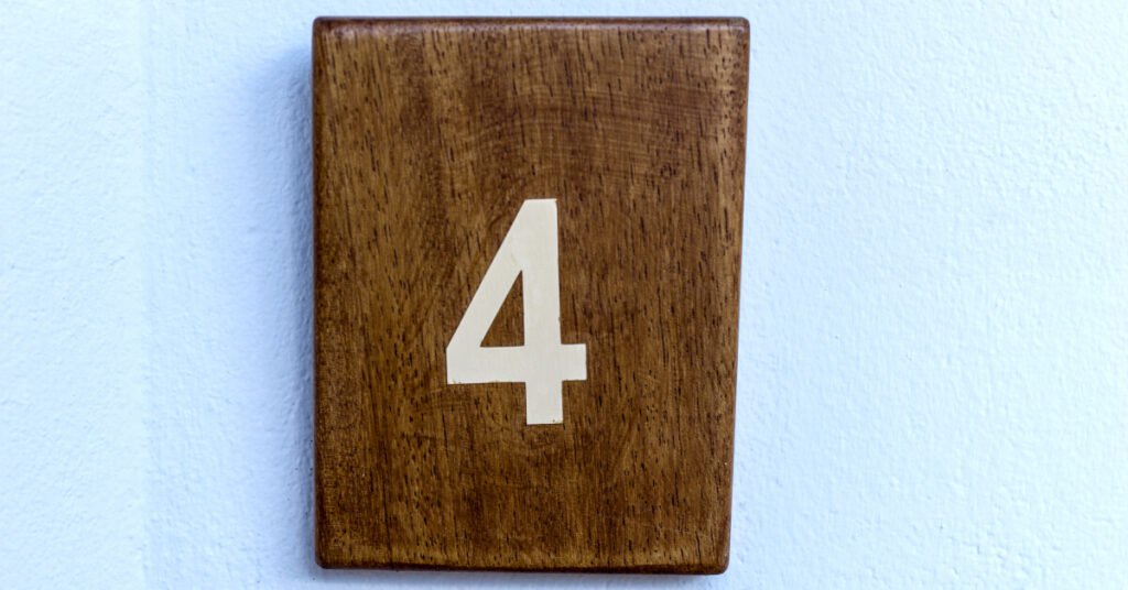 the number four on a stained piece of wood