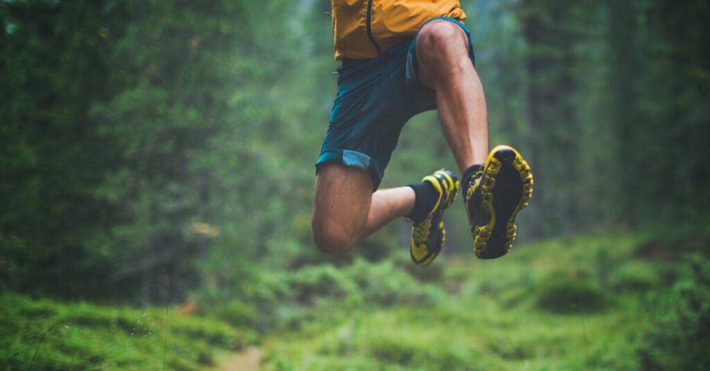 Man jumping on forest trail