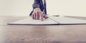 man pointing to paperwork on table