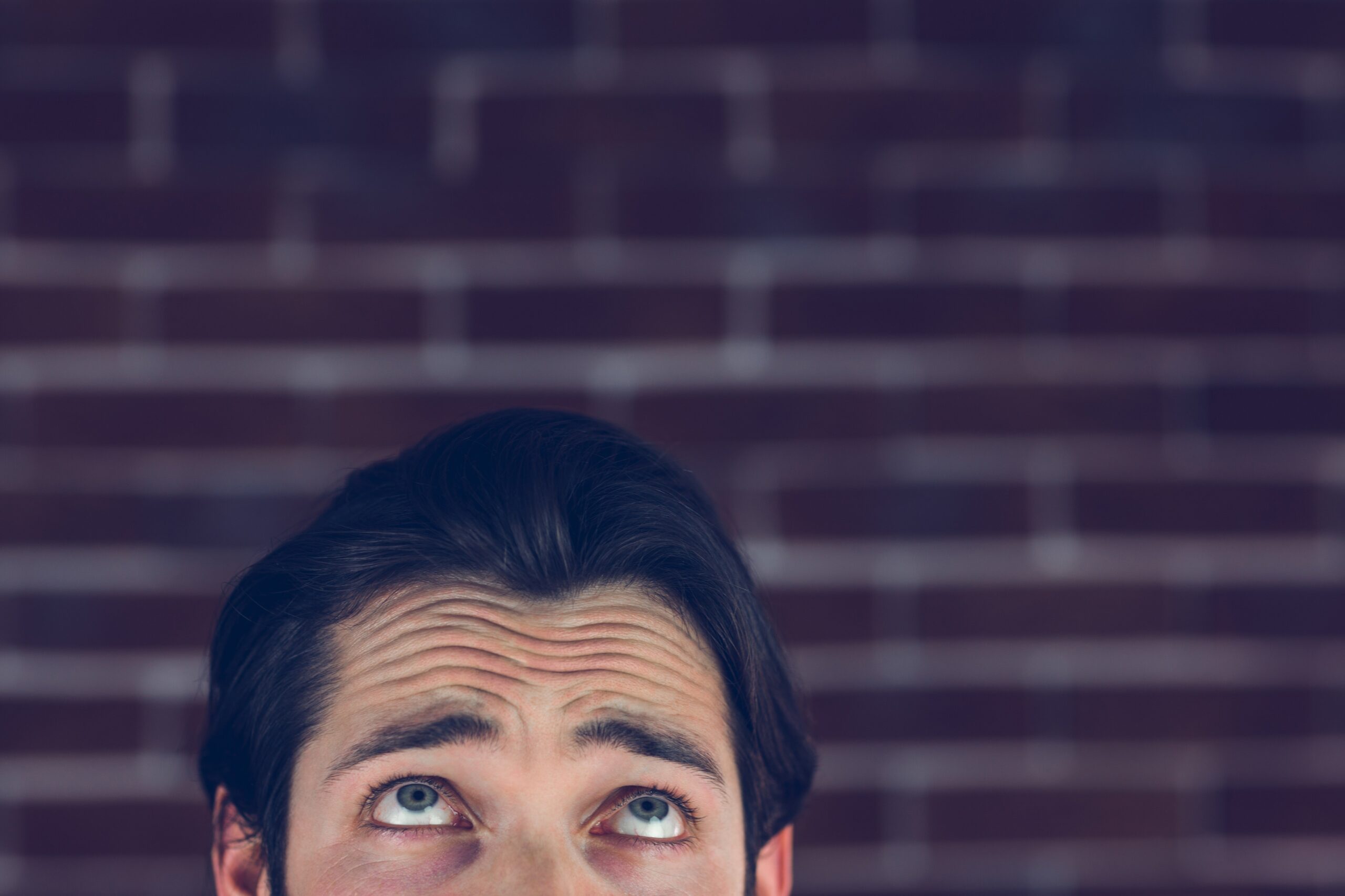 Man In Front Of Brick Wall Staring Up
