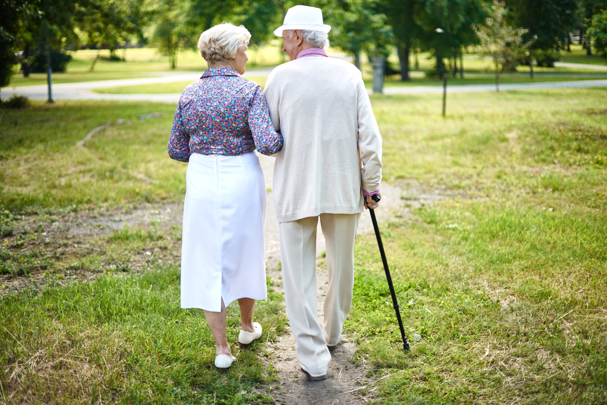 Elderly Couple Walking Through Park