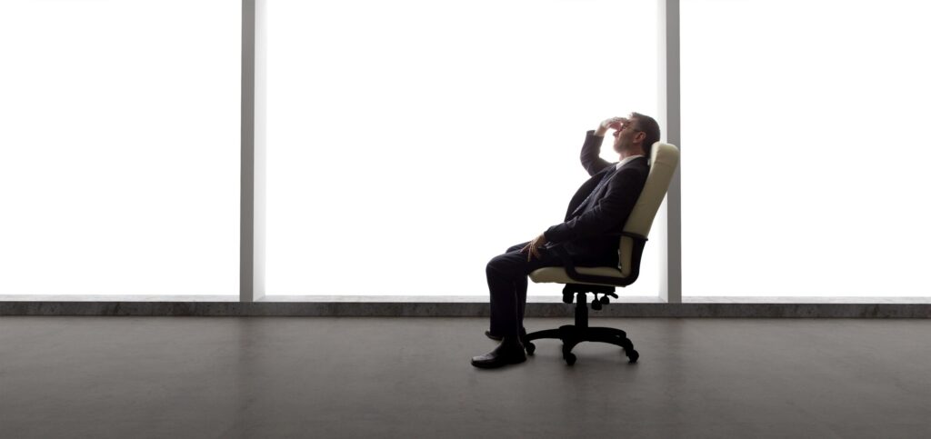 man sitting in chair in empty office