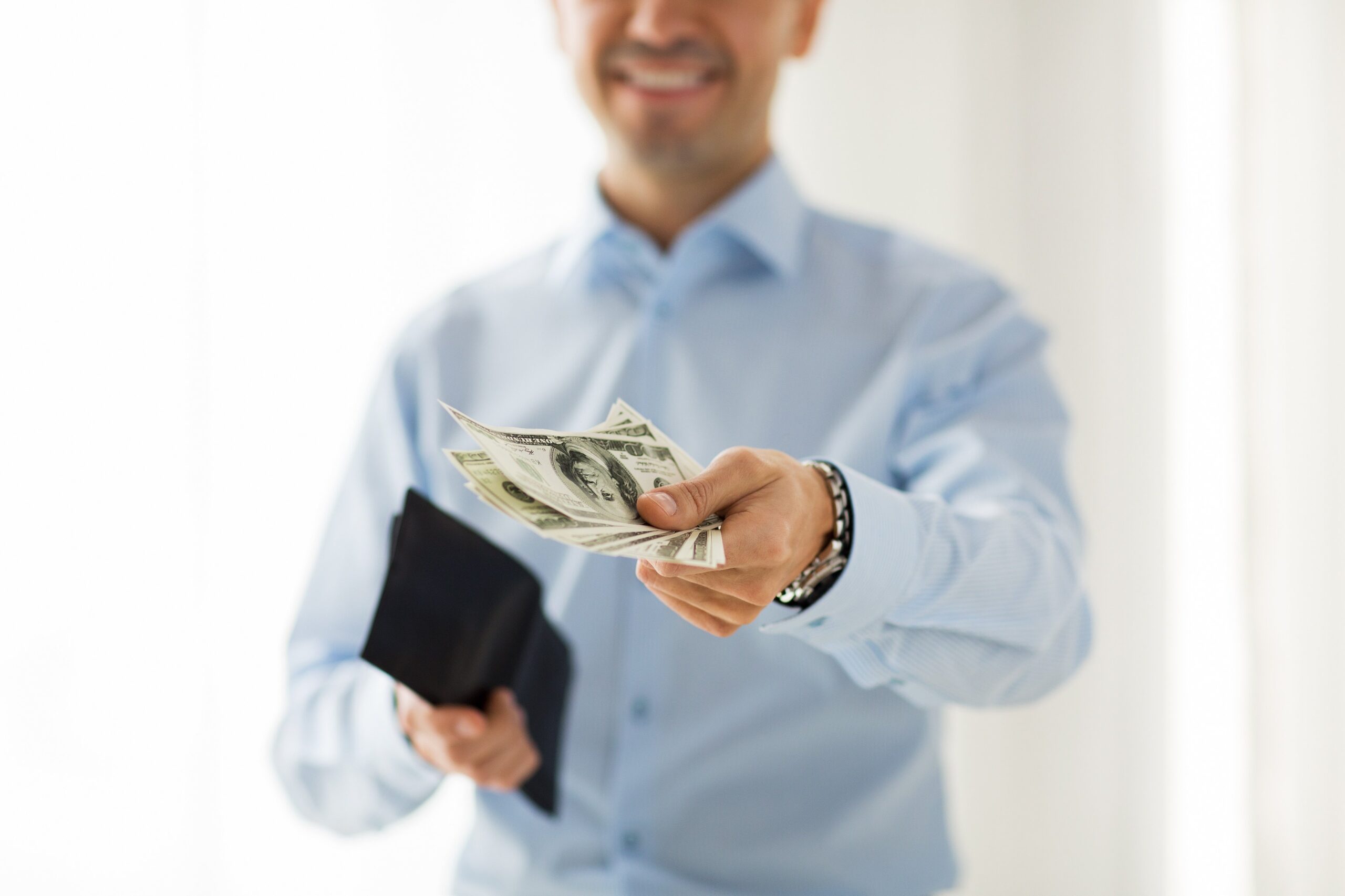 Man Holding Wallet And Stack Of One Hundred Dollar Bills