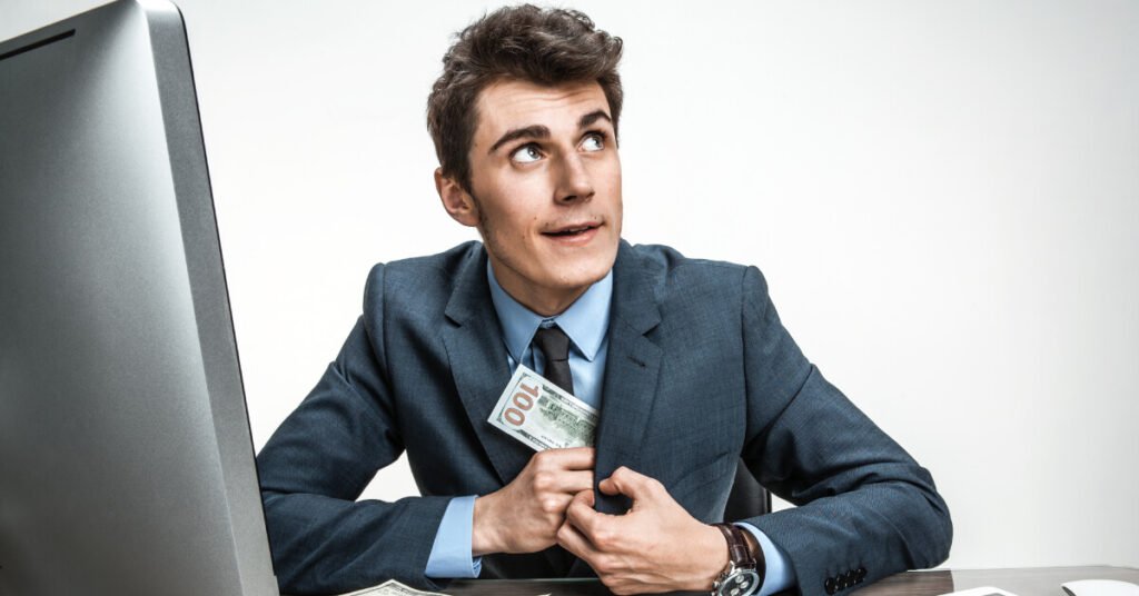 man putting one hundred dollar bill in suit jacket