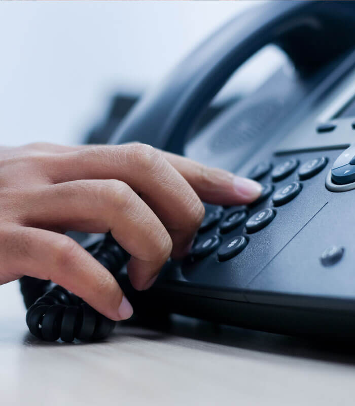 woman pressing numbers on telephone